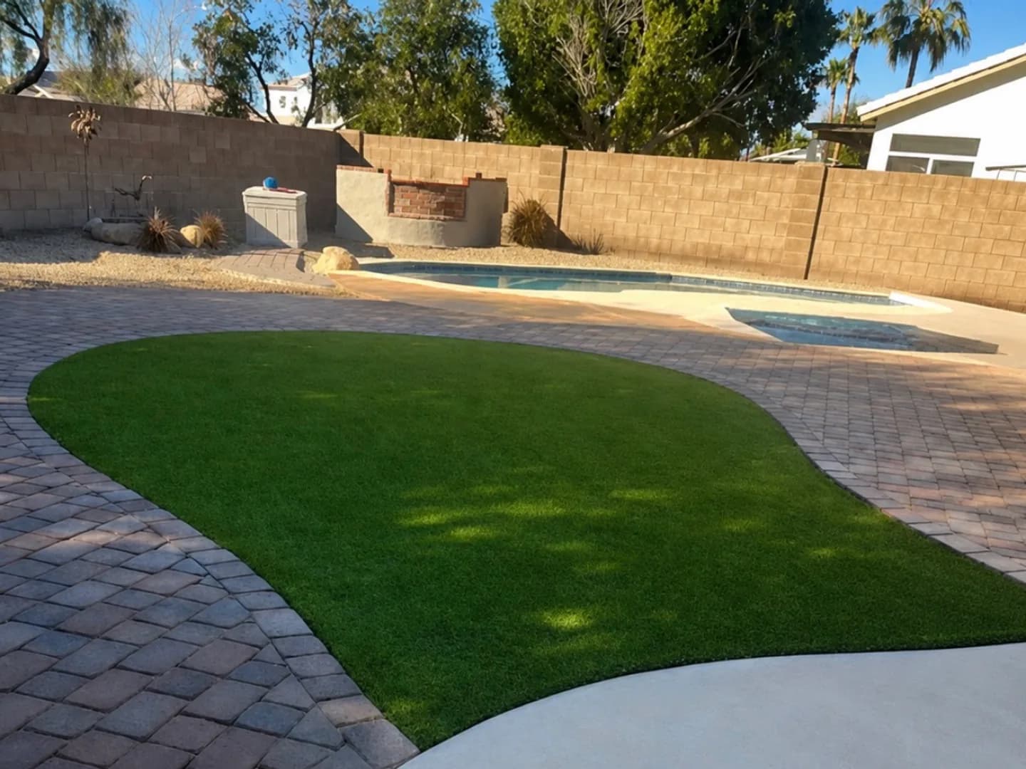 Curved pavers & turf beside the pool